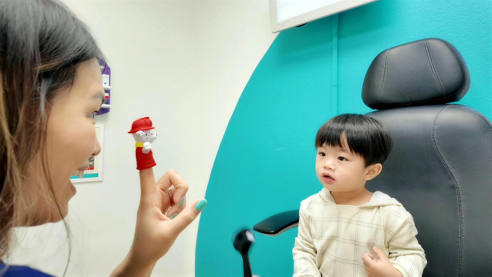 Dr. Tran making a young patient smile during an eye exam at Aura Eye Center